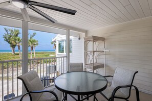 A covered outdoor area with a table and chairs, a ceiling fan, and a view of the ocean. - Dunes of Boca 2 | 3 bedroom 3 Bath | Pool | Gulf Front | Tennis | Sleeps 6 (Boca Grande)