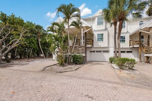 A beachfront property with a paved driveway, multiple-story buildings, and palm trees. - Dunes of Boca 2 | 3 bedroom 3 Bath | Pool | Gulf Front | Tennis | Sleeps 6 (Boca Grande)