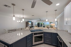 A modern kitchen with a central island, built-in oven, and pendant lighting. - Dunes of Boca 2 | 3 bedroom 3 Bath | Pool | Gulf Front | Tennis | Sleeps 6 (Boca Grande)
