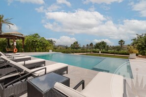 Ein Schwimmbecken mit Liegestühlen und einer Pergola.