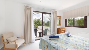 A hotel room with a bed, a chair, a small table, and a window. - La Manga Club Individual Villa 619 (Atamaría)