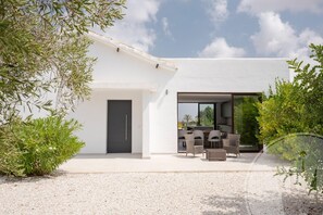 A modern house with a patio area featuring outdoor furniture. - La Manga Club Individual Villa 619 (Atamaría)