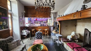 A traditional interior with a bar area, wooden furniture, and a fireplace. - Chateau d'Urbilhac (Lamastre)