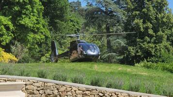 A helicopter parked on a grassy area with trees in the background.