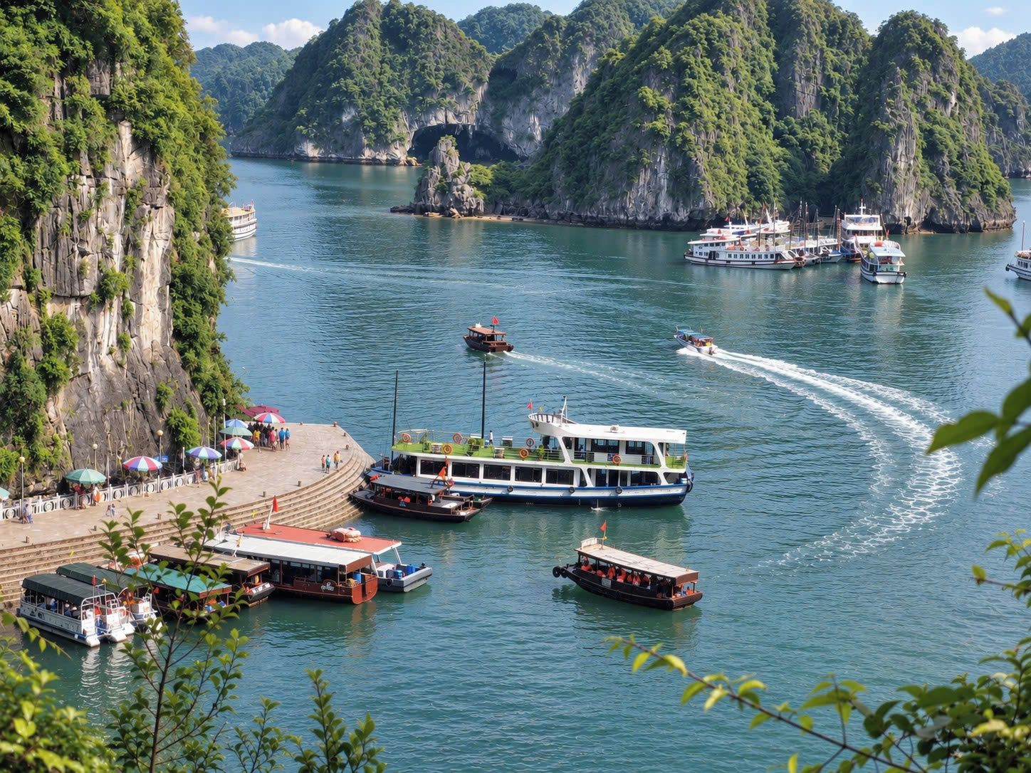A coastal area with boats docked at a pier, surrounded by lush green cliffs.