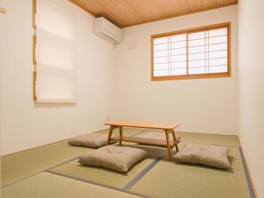 A tatami mat room with a low wooden table and cushions. - Chayaju (Osaka)