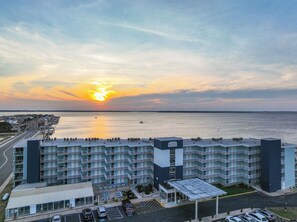 Ein mehrstöckiges Hotel mit Blick auf eine Bucht, mit Balkonen und einem Parkplatz.