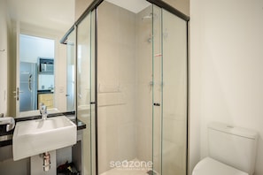 A modern bathroom with a glass shower enclosure, a white sink, and a visible toilet. - Complete Studio in Paraiso-sp Onp0920 (São Paulo)