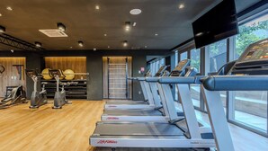 A gym with multiple treadmills, exercise balls, and a wall-mounted TV. - Studio in Cond. w/ Pool in Paraiso Onp1701 (São Paulo)