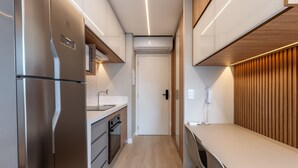 Eine kleine Küche mit Kühlschrank, Backofen und Arbeitsfläche.
