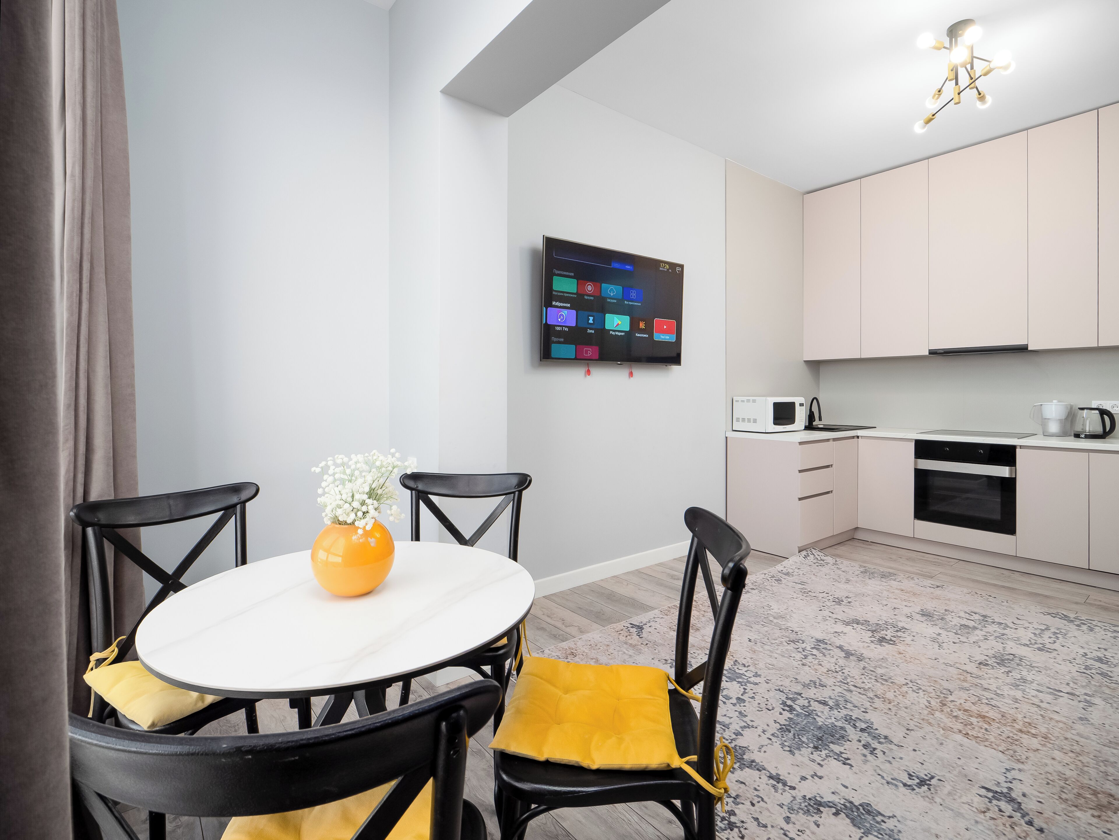 A modern kitchen with a flat-screen TV, a microwave, and a coffee maker.