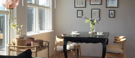 A dining area with a table, chairs, and a vase of flowers.