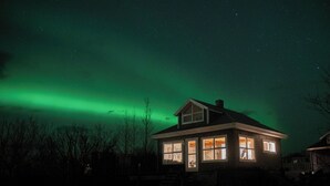 Ein Haus mit vielen Fenstern und einer sichtbaren Treppe zum Eingang.