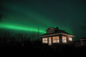 A house with multiple windows and a visible staircase leading to the entrance. - A Historic Icelandic Lakeside Home, where nature and people reconnect (Selfoss)