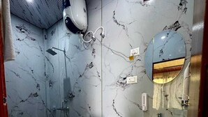 Ein Badezimmer mit Toilette, Waschbecken, Spiegel und Dusche.