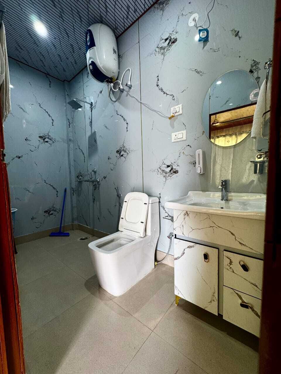 Un baño con inodoro, lavamanos, espejo y ducha.