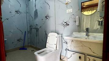 Un baño con inodoro, lavamanos, espejo y ducha.
