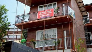Ein zweigeschossiges Gebäude mit einem Balkon im oberen Stockwerk.