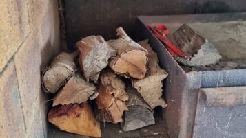 A stack of firewood and metal containers on a concrete floor.
