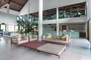 A spacious lobby with a high ceiling, a staircase, and a reception desk. - BeachClass EcoLife Porto de Galinhas (Ipojuca)