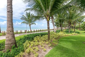A coastal landscape with palm trees, a sandy path, and a grassy area. - BeachClass EcoLife Porto de Galinhas (Ipojuca)