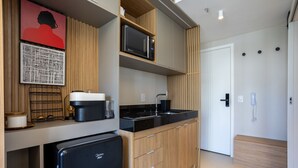 A compact kitchen with a microwave, coffee maker, and a refrigerator. - Beautiful Studio 800m From the Metro Oag0505 (São Paulo)