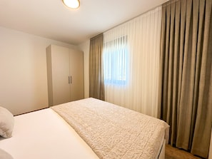 A hotel room with a bed, a wardrobe, and a window with curtains. - Villa Sorelle 1 & Sorelle 2 (Zaton)
