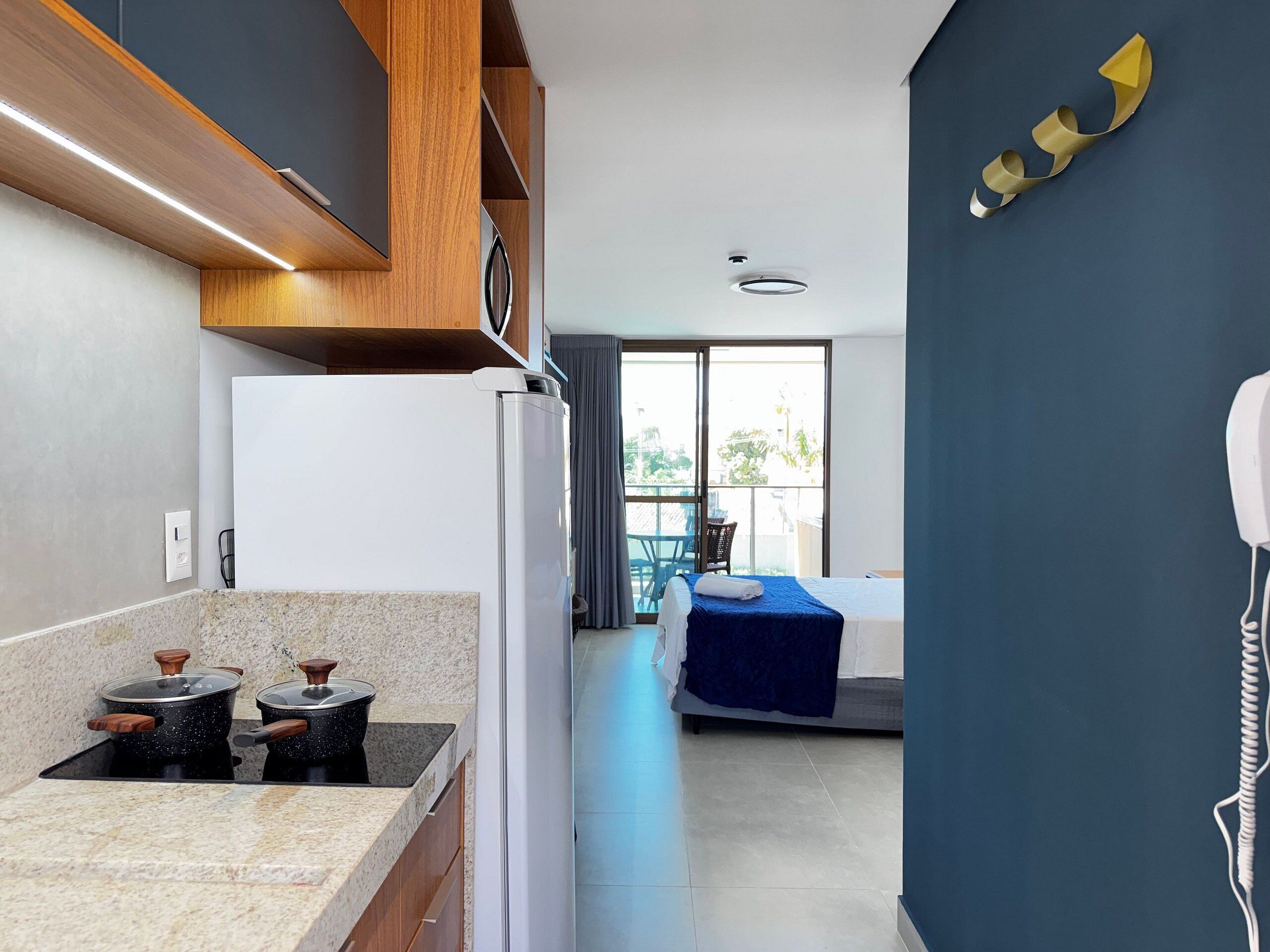 Una cocina moderna con estufa integrada, refrigerador y comedor con mesa y sillas.