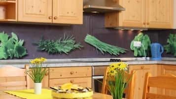 Una cocina con armarios de madera, estufa y una mesa de comedor con sillas.