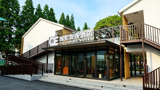 A hotel with a modern design, featuring a prominent glass facade and a staircase leading to the entrance.