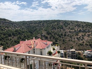 A building with a red-tiled roof, white walls, and balconies with metal railings. - Casa Panorama in Voula - Panoramic Sea View Villa (Vari-Voula-Vouliagmeni)