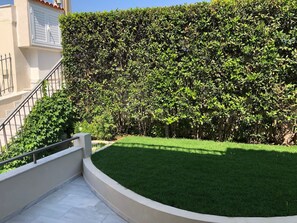 A well-maintained hedge, a curved pathway, and a building with a balcony. - Casa Panorama in Voula - Panoramic Sea View Villa (Vari-Voula-Vouliagmeni)