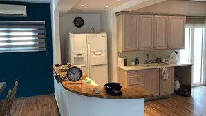 Una cocina moderna con isla integrada, electrodomésticos blancos y armarios de madera clara.