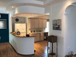 A modern kitchen with a curved island, wooden cabinets, and a built-in oven.