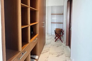 Ein Flur mit einem Holzschrank, einem Stuhl und einem Fliesenboden.