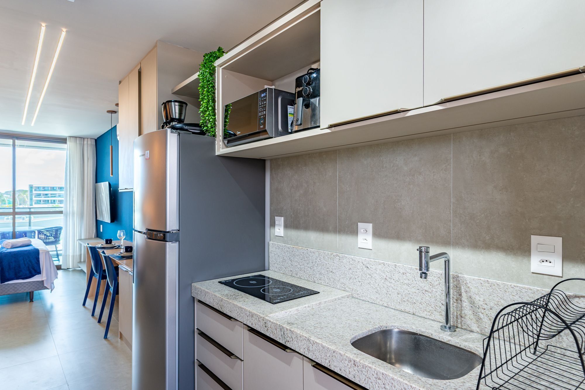 A modern kitchen with a built-in refrigerator, a sink, and a countertop with a built-in induction cooktop.