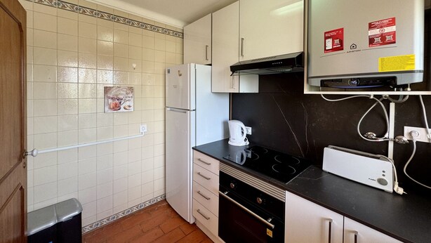 Una cocina compacta con refrigerador, estufa y microondas.