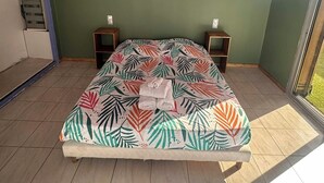 A bedroom with a bed, two bedside tables, a wardrobe, and a window. - T2 tout confort avec terrasse de 30 m² et Wi-Fi – Proche plage de Canet (Canet-en-Roussillon)