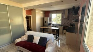 A compact living space with a sofa, a kitchenette, and a dining area. - T2 tout confort avec terrasse de 30 m² et Wi-Fi – Proche plage de Canet (Canet-en-Roussillon)