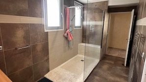 Et moderne badeværelse med en glasbrusekabine, et badekar og et toilet.