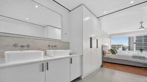 A modern bathroom with dual sinks, a large mirror, and a vanity cabinet. - Ocean View Apartment near V&A Waterfront (Cape Town)