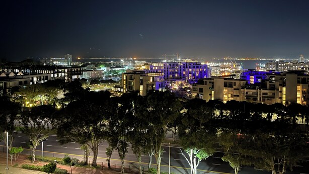 A nighttime cityscape with illuminated buildings and a clear view of the street. - Ocean View Apartment near V&A Waterfront (Cape Town)