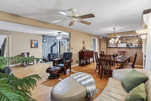 A spacious living room with a fireplace, a dining area with wooden furniture, and a kitchen with modern appliances. - Charming 3-bedroom cottage with AC in beautiful Georgian Bay (Georgian Bay)