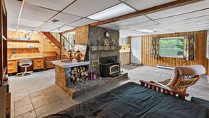 Una zona de estar acogedora con chimenea, un sillón cómodo y vistas al exterior.