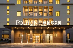 A building with a sign reading 'POLTON SERVICE APARTMENT'.