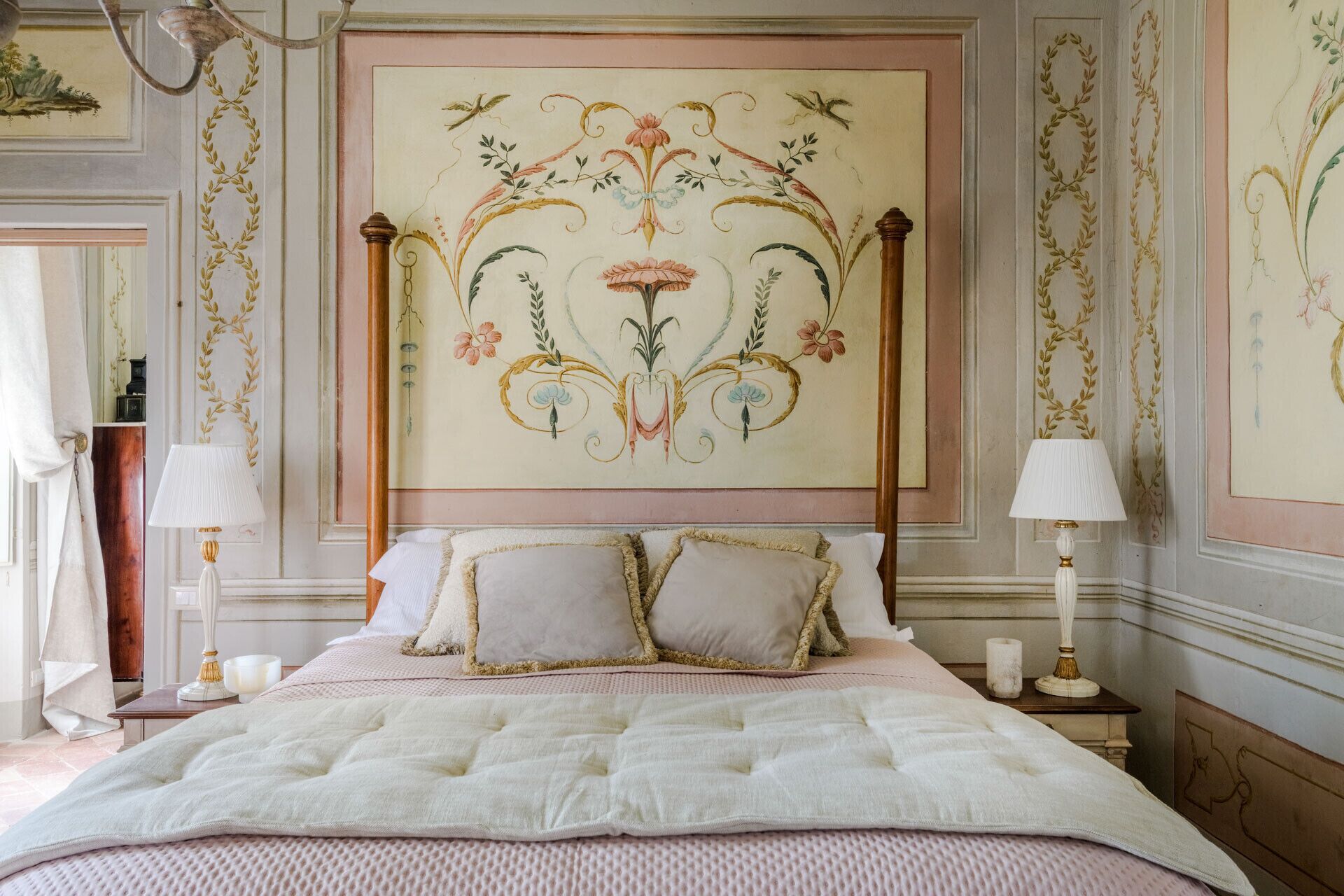 Un dormitorio con una cama grande, dos mesitas de noche y un mural decorativo.