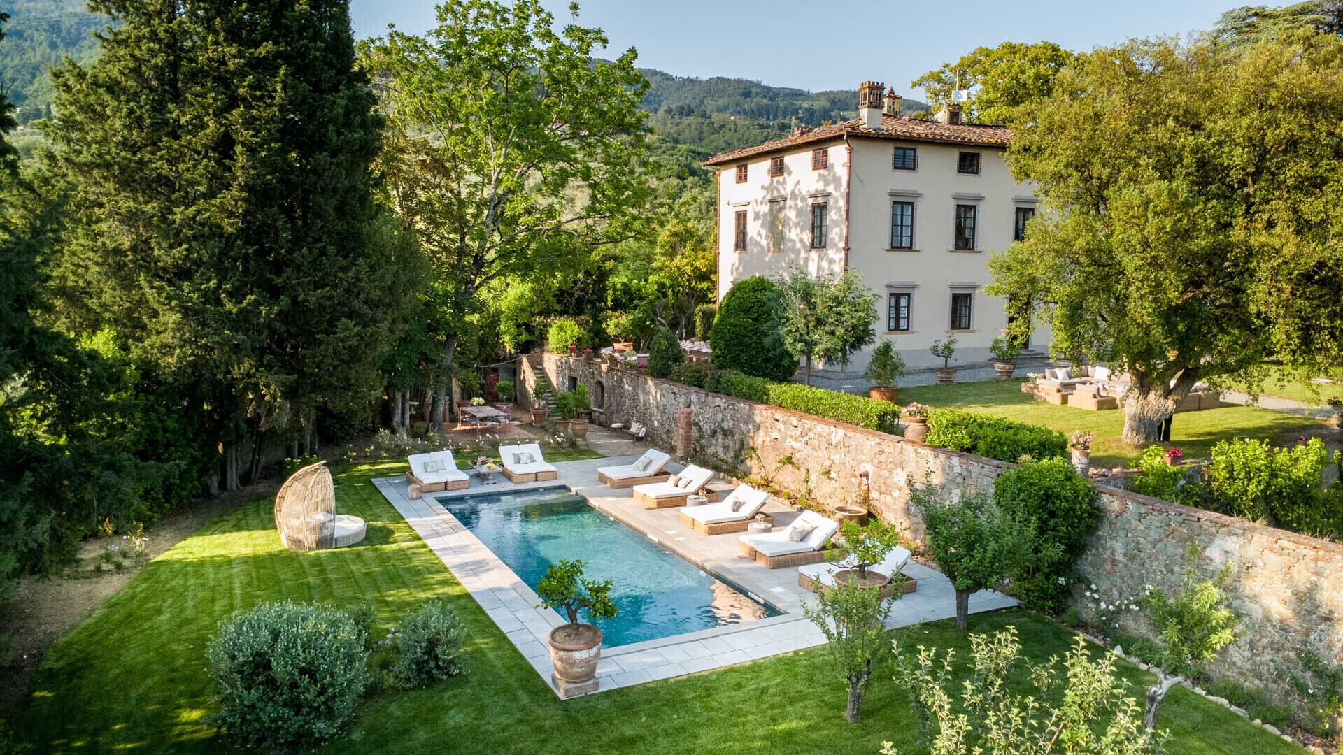 Un espace piscine avec des chaises longues et un mur en pierre.