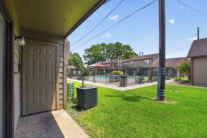 A residential property with a front yard, a swimming pool, and a covered patio area. - Regency Place | Modern Comfort, 2BR Home (Beaumont)