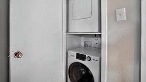 Ein Waschraum mit einer Frontlader-Waschmaschine und einem Toplader-Trockner.