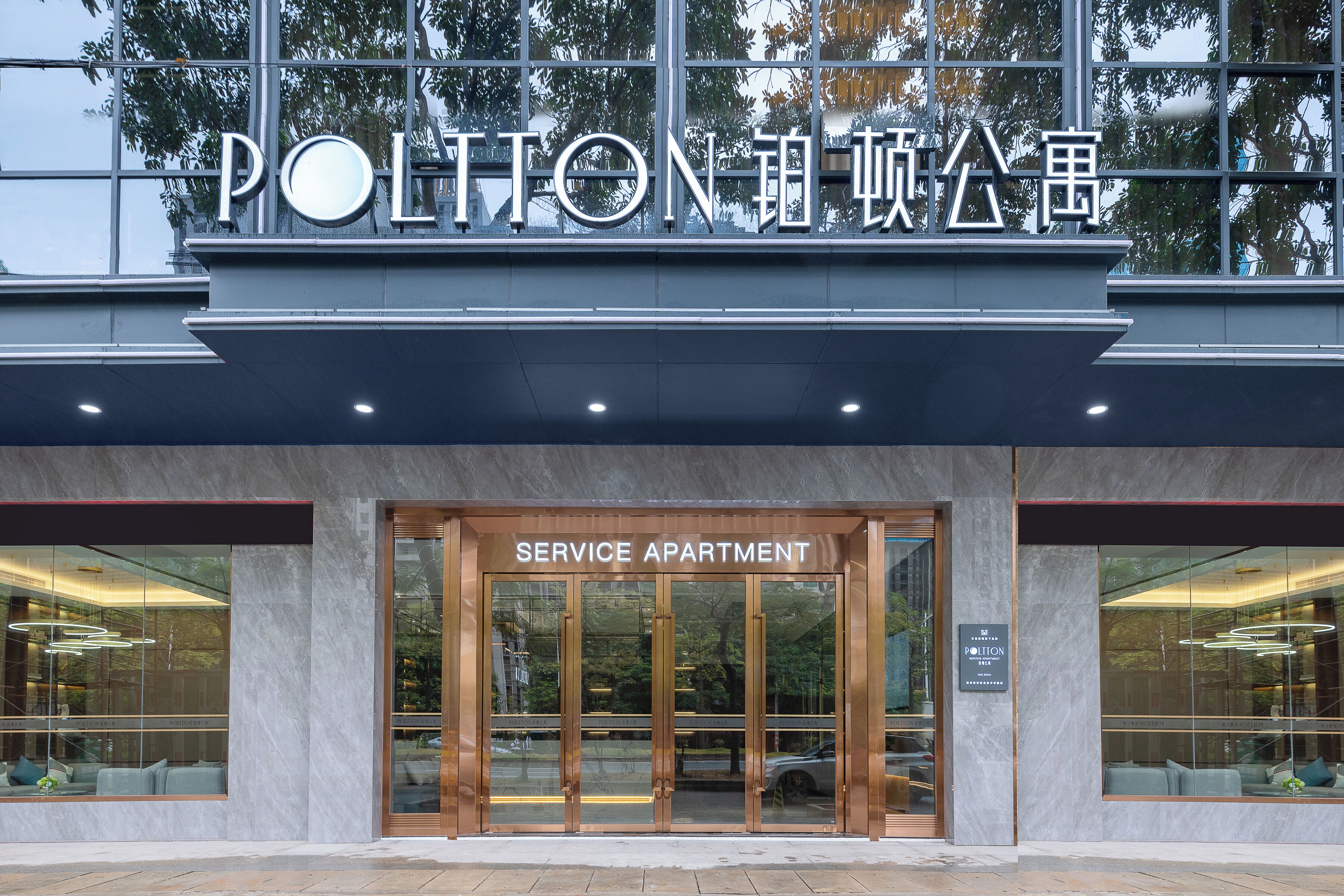 Een gevel van een gebouw met een bord waarop 'SERVICE APARTMENT' en 'POLITON' staat.